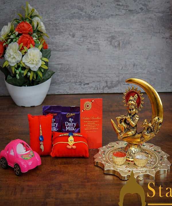 StatueStudio Rakhi Gift For Bhaiya Bhabhi & Kids With Rakshabhandhan Gift Hamper Combo - Lumba Rakhi & Kids Rakhi, Kum Kum Dabbi, Greeting Card, 2 pcs Dairy Milk, Roli Chawal, Toy Car, Pooja Thali & Metal Krishna Moon Showpiece