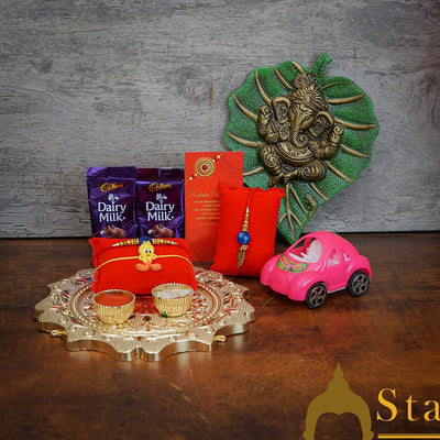 StatueStudio Rakhi Gift For Bhaiya Bhabhi & Kids With Rakshabhandhan Gift Hamper Combo - Lumba Rakhi & Kids Rakhi, Kum Kum Dabbi, Greeting Card, 2 pcs Dairy Milk, Roli Chawal, Toy Car, Pooja Thali & Pan Leaf Ganesha