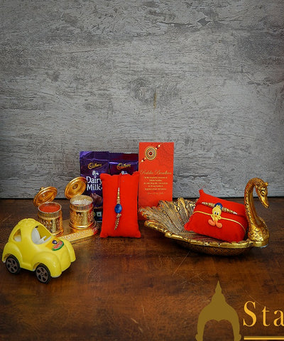 StatueStudio Rakhi Gift For Bhaiya Bhabhi & Kids With Rakshabhandhan Gift Hamper Combo - Lumba Rakhi & Kids Rakhi, Kum Kum Dabbi, Greeting Card, 2 pcs Dairy Milk, Roli Chawal, Toy Car, Metal Duck Tissue Holder